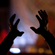 A woman raises her hands during an ayahuasca session in a remote village in the Amazonian jungles of Peru.